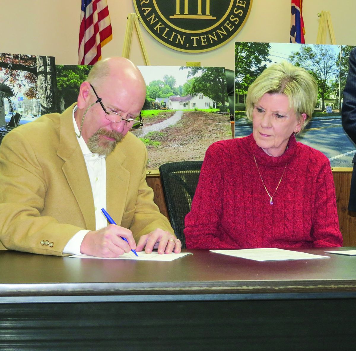 Reid and Brenda Lovell sign sale documents of their property to the