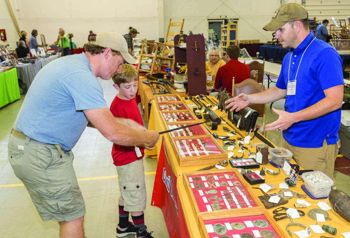 Matt and Bobby Ayers of Port Jervis, New York, take a close look at the details of a bayonet. Chris Harwick of Civil War Shot and Shell of East Petersburg, Pennsylvania, keeps a safe distance from the business end as father explains to son how the bayonet would be fixed to the musket.