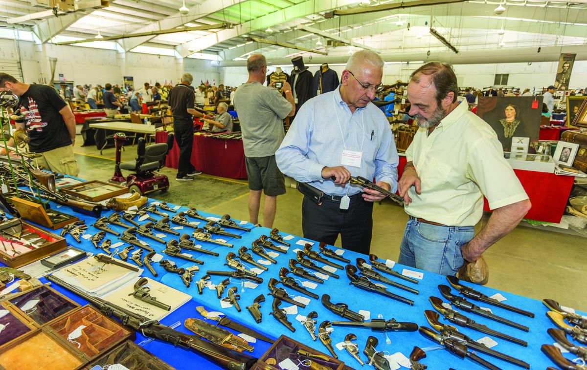 Vin Caponi of Malverne, New York, left, came to the Artifacts and Collectibles show with enough firepower to arm a regiment, including a revolver that caught the eye of Bob Simms, right.