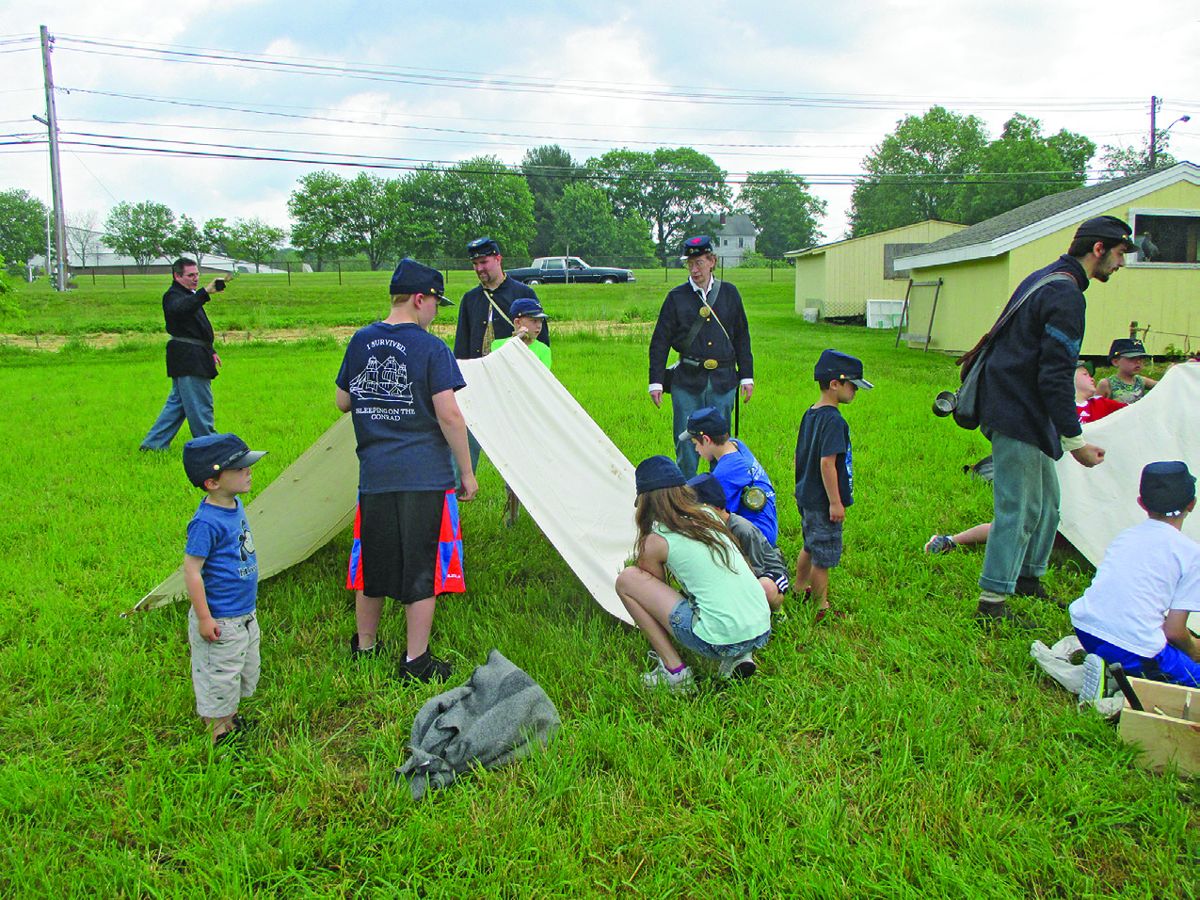 The photos show 14th CVI Co G members helping the campers in the tent set up activity and General Lee and General Grant bringing the day