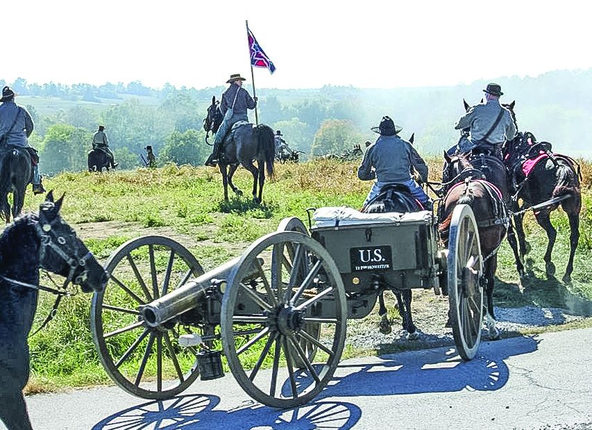 Artillerist pulling a limber and 12-pounder howitzer into battle.