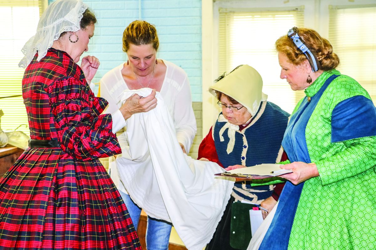 Marylou Wells presents her authentically constructed underpetticoat to the Judges during the Costume Competition on Saturday afternoon. An underpetticoat was the special project clothing item for the 134th Nationals, for which the Susan Brisban Award is given. Judy Stoneburner won the award this year for her underpetticoat. Pictured are Marylou Wells, Maryanne Greketis, Peggy Edward-Shaw, and Sharleen Mullins.