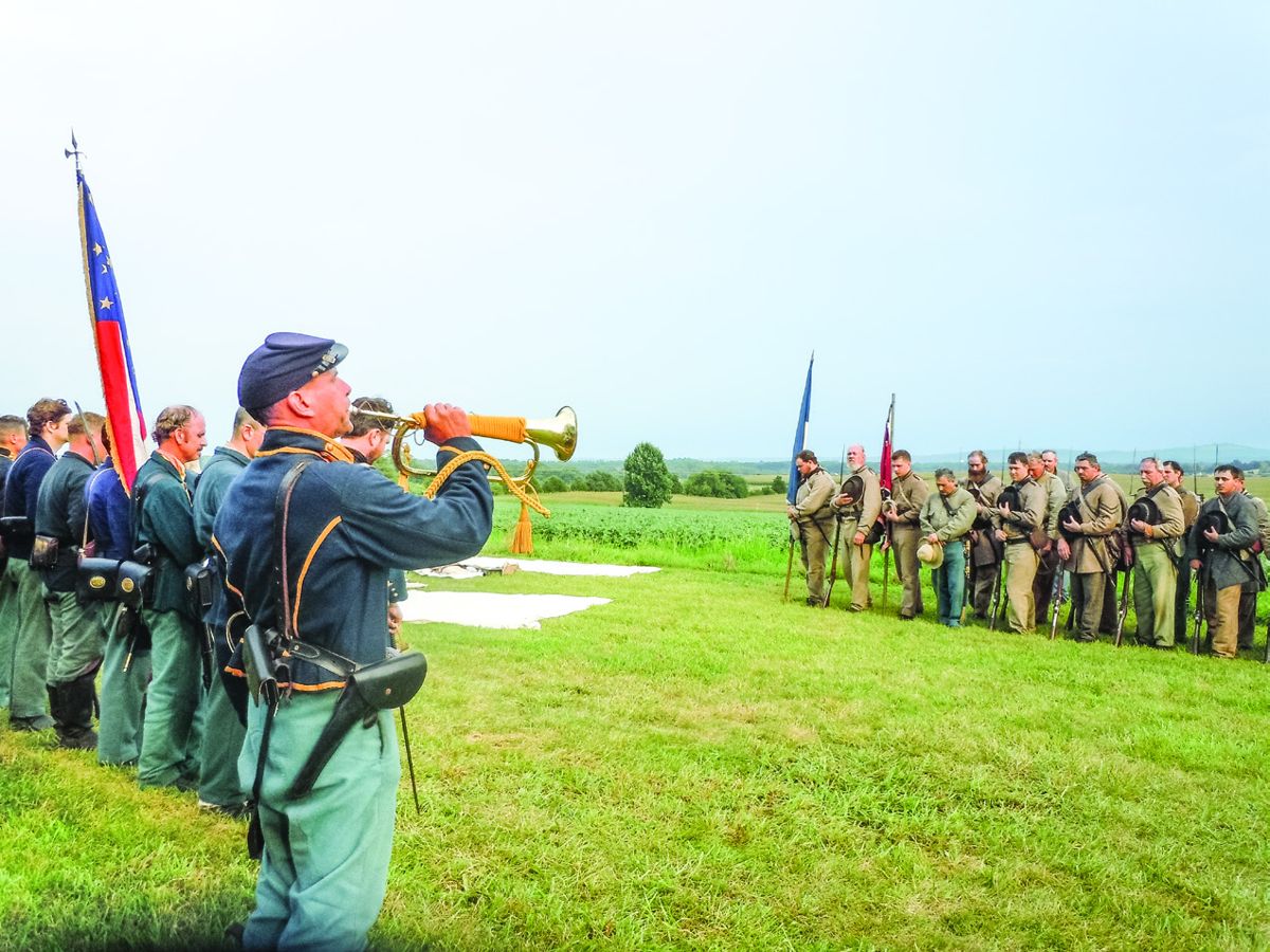 Ken Doyon playing Taps to the group of reenactors. (Katelyn Bitely)