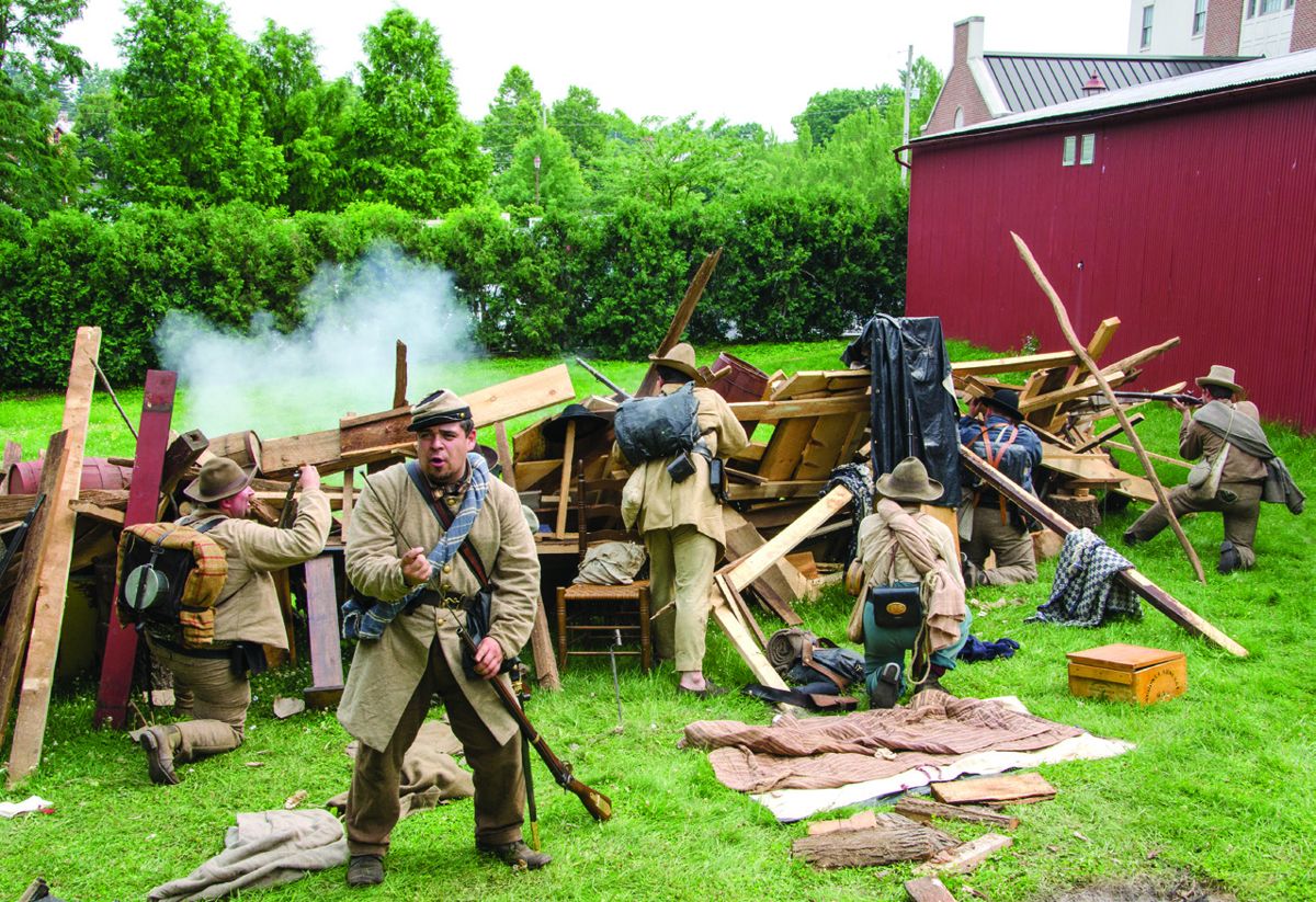 Outside of the Farnsworth House Inn-Blackford’s Sharpshooter, the 5th Alabama Infantry Civil War reenactors. Facing the front: Major Eugene Blackford as portrayed by Brian Schade. Schade tells the spectators how Blackford’s Sharpshooters were involved in the Battle of Gettysburg as the Confederate reenactors attempt to defend themselves.