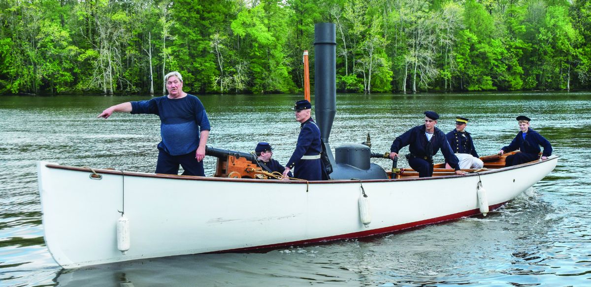 Allen Mordica with the Tidewater Maritime Living History Association points out a deadhead – a piece of driftwood – in the Roanoke River. The boat is a replica of the steam-powered launch that Lt. Cushing used to sink the Albemarle.