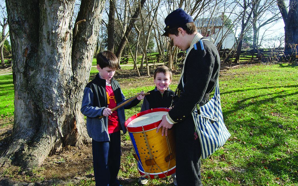 Drummer Ryan LeVault from Herndon, Va., with the 13th Virginia Infantry, Co. I, talks about Civil War musicians with brothers Jack Moreth, 7, and Daniel, 6, from Annandale, Va.
