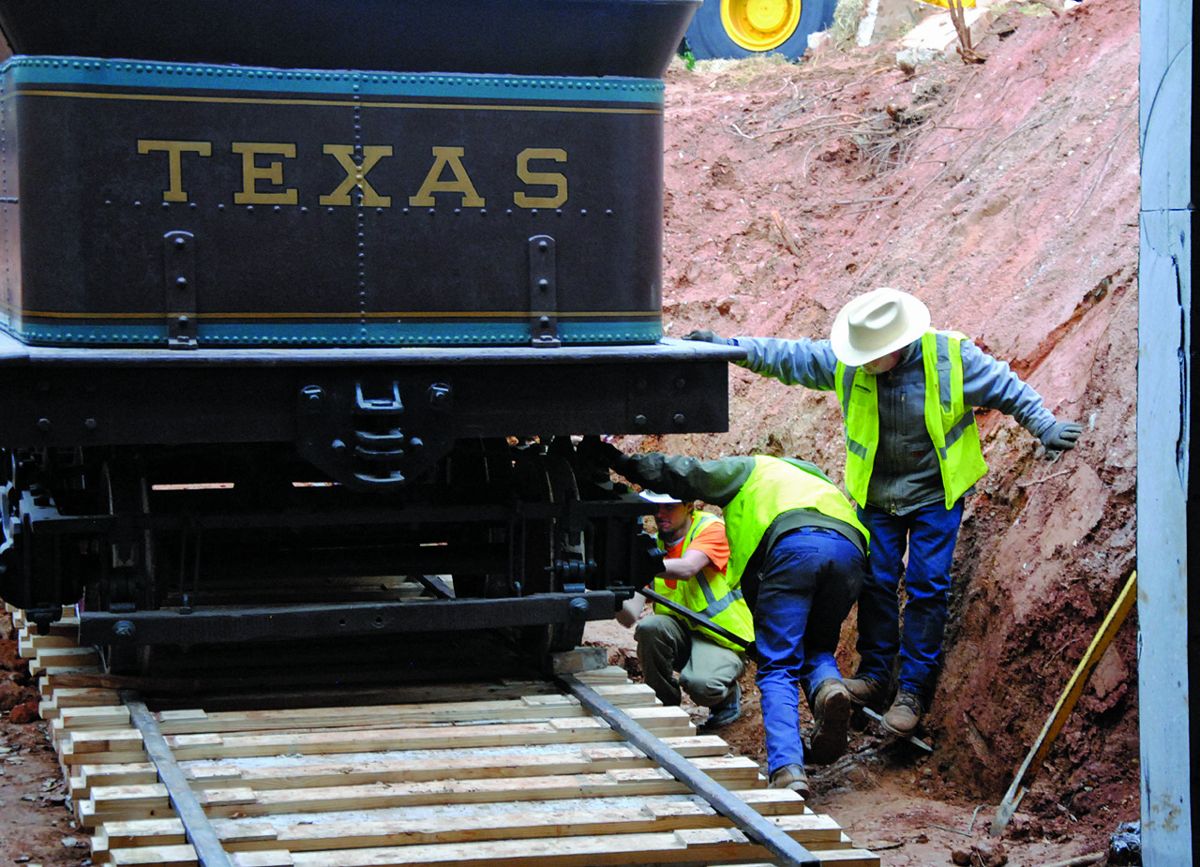 Nathaniel Watts, Stephen Newell, and Lynn Gause make final adjustments before the Texas’s 20,000 lb. tender car is lifted from the Cyclorama building. (Atlanta History Center)