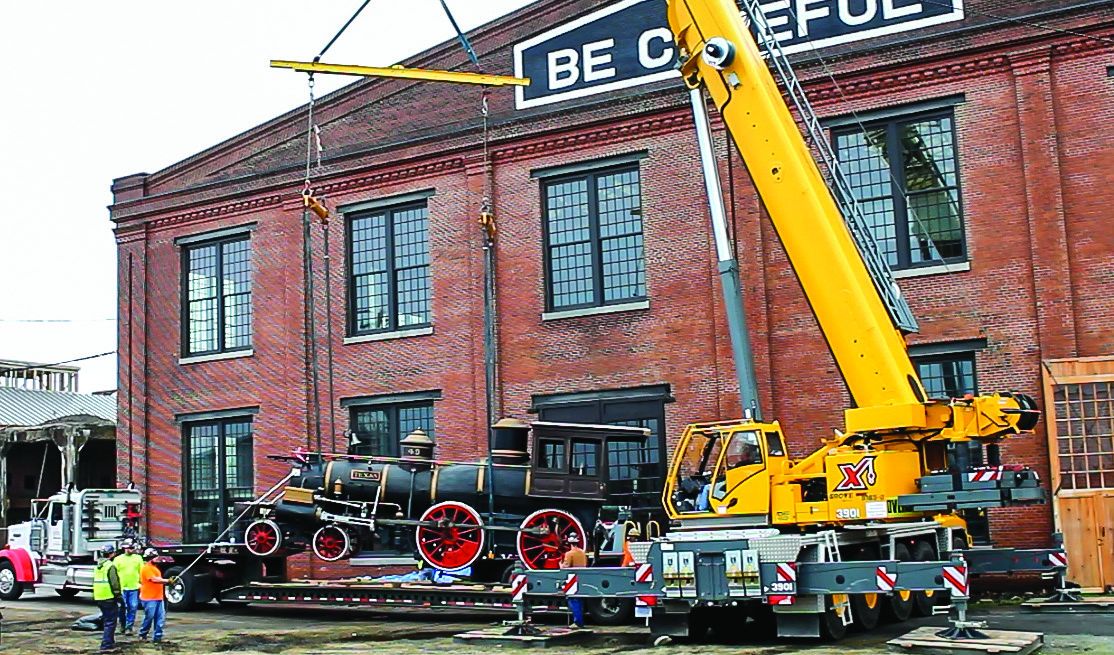 The Texas is lifted into the Back Shop at the North Carolina Transportation Museum under the famous motto painted onto the 1905 building. (North Carolina Transportation Museum)