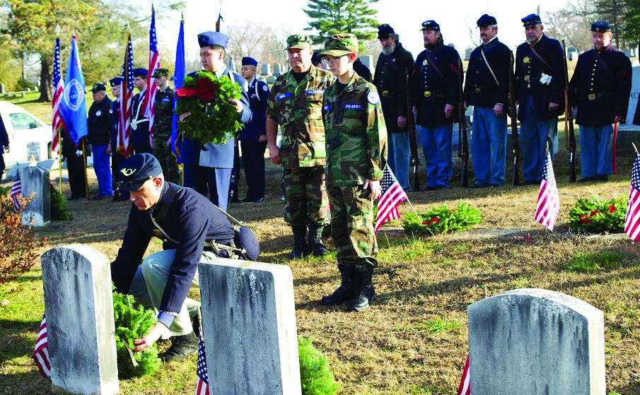 Pvt. Raul Pinto places a wreath on a Civil War veteran’s grave.