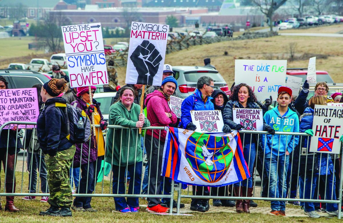 The small organized group of protesters were led by Scott Hancock, a Gettysburg College professor who is standing in the center holding a sign comparing the Confederate flag to a Nazi swastika.