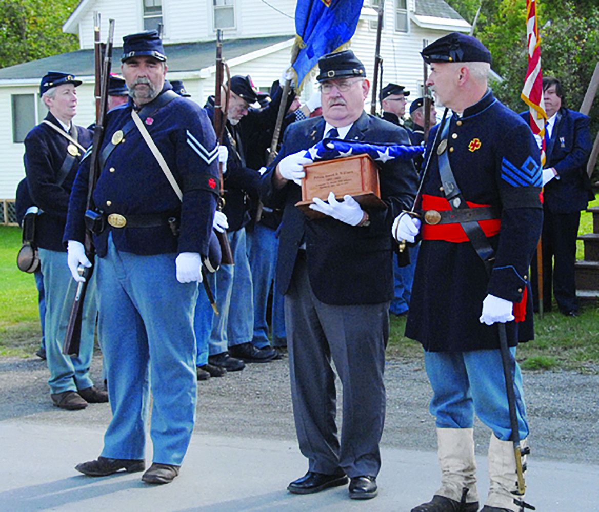 Flanked by two 20th Maine Infantry reenactors outside the Hodgdon United Methodist Church, Morris Berry (center) of Spruce Head holds the urn containing the cremains of Pvt. Jewett B. Williams of Hodgdon.