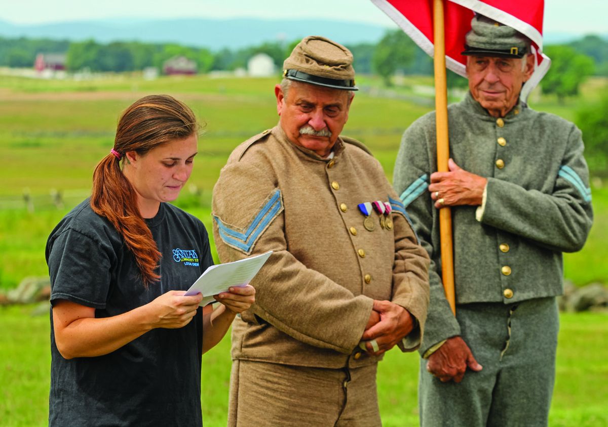 Danielle Clarke reads from the Thirty-Eighth Virginia list as Gettysburg Culp SCV Camp Rich Mayesky and Bob Doerr look on.