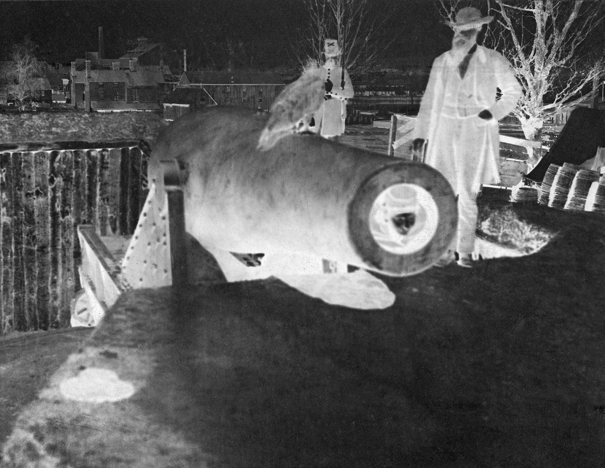 Russian sailor poses with large owl in 15-inch Rodman smoothbore, Battery Rodgers, near Alexandria Va.