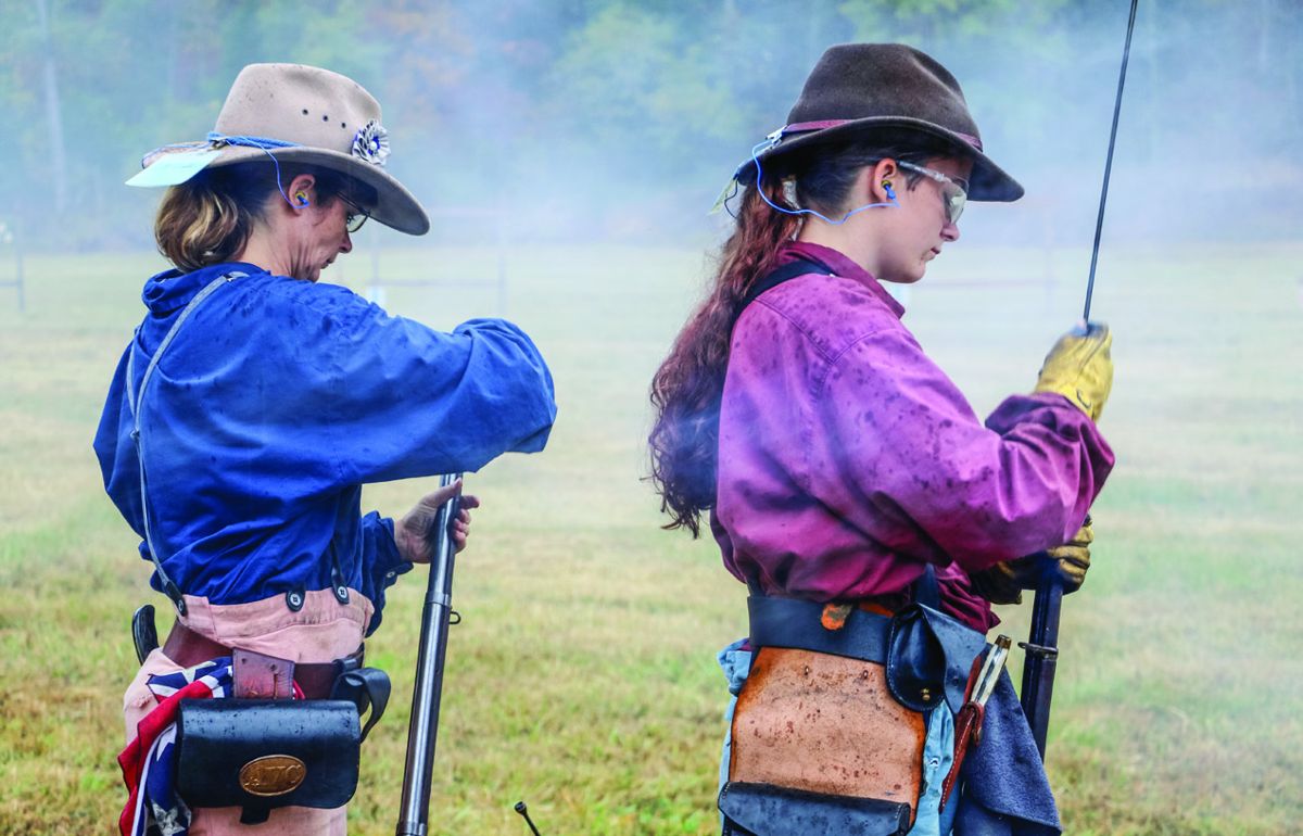 Two competitors carefully load their muskets in the Sunday morning rain at the 136th National Skirmish musket company