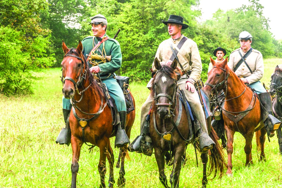 Confederate cavalrymen ride towards the Union forces during