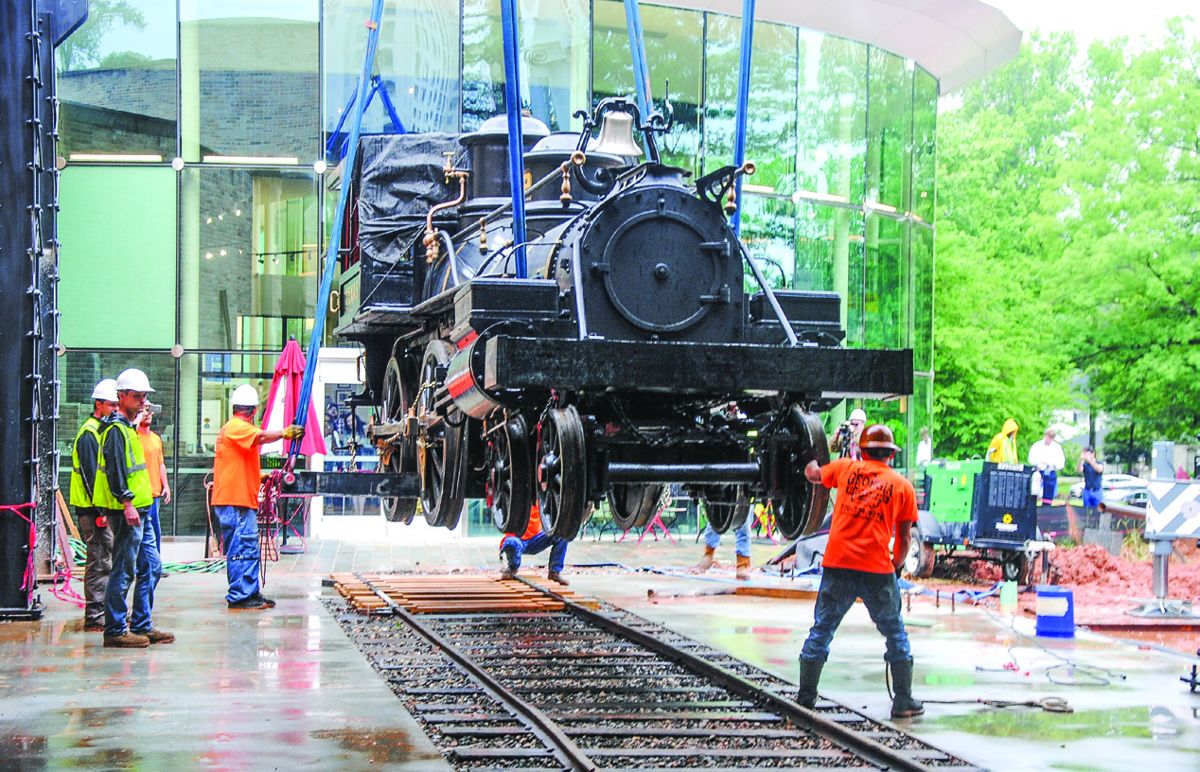 The Texas is gently lowered onto original 1880s-era tracks at the Atlanta History Center by the Georgia Rigging Company. With the locomotive in place, the glass-walled exhibit area can be completed.