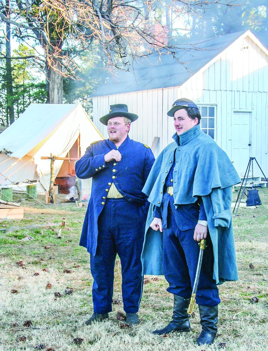 Jeremy Brandt and Tyler Grecco, standing in front of the cook house, supervise early morning roll call.