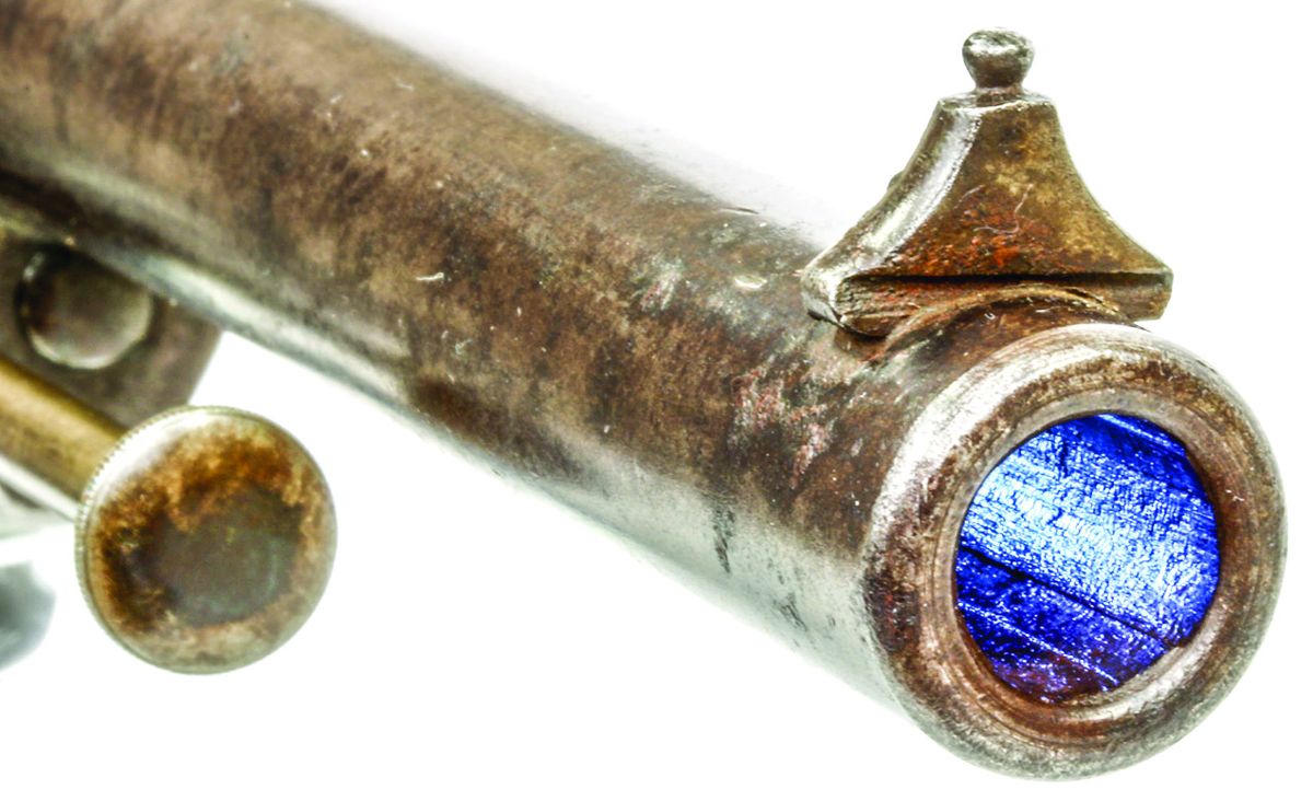 View of M-1854 revolver #28256 showing the very European style front sight with a dovetailed pyramidal base and bead on top, the rifling and the ejector rod’s button head with knurled edge.