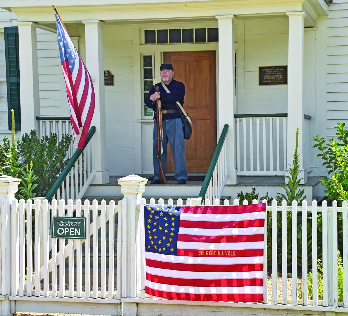 Neil Bray stands on guard duty on the front porch of the William Root house.
