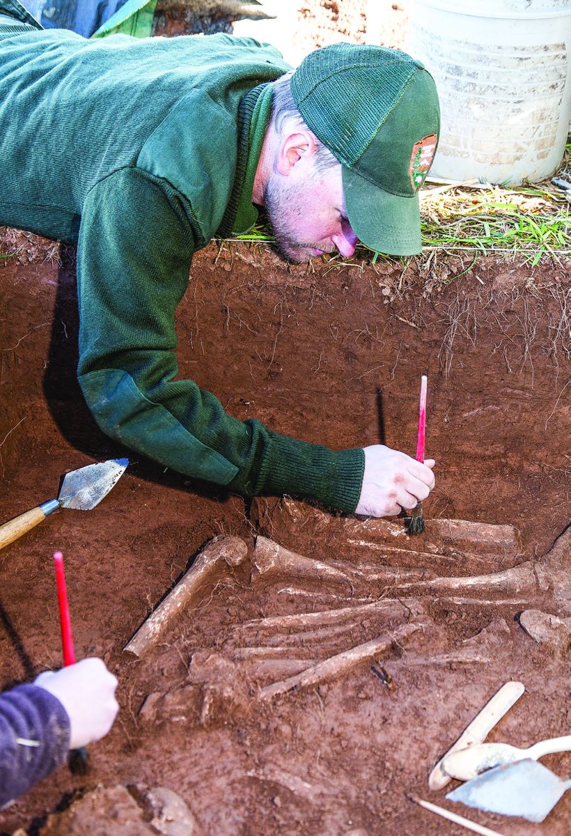 Manassas National Battlefield Park Superintendent Brandon Bies, then an archaeologist, examines the remains of Civil War soldiers in a surgeon’s pit found at Manassas National Battlefield (Smithsonian Institution)