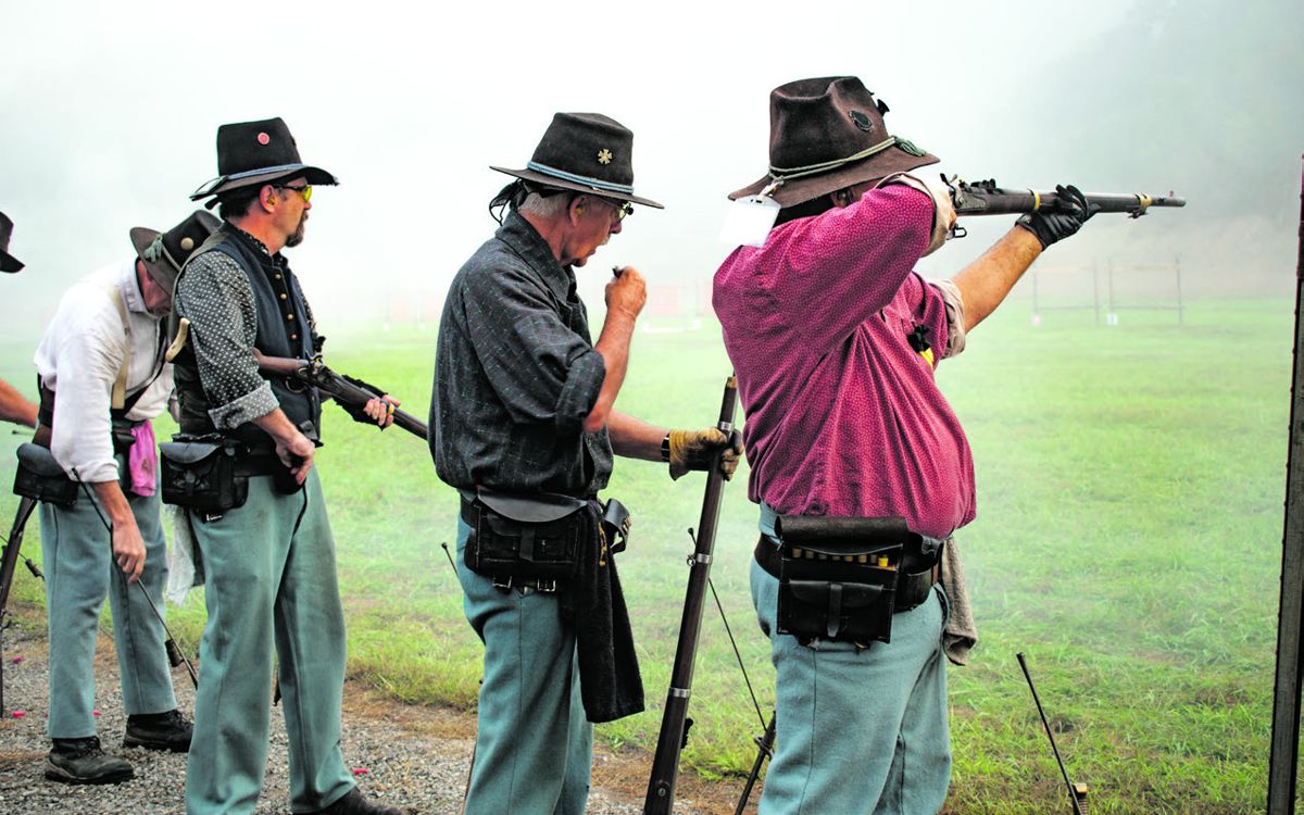 The Union Guard musket team, including father and son Bill and Mike Jordan, fire through the morning fog and smoke at the clay pigeon targets.
