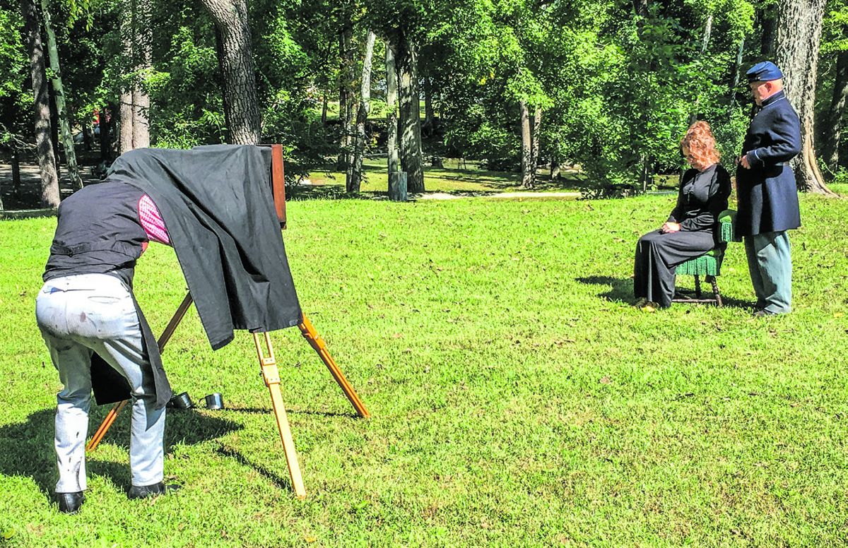 Tintype photographer Michael Rhodes prepares to capture the image of two reenactors.