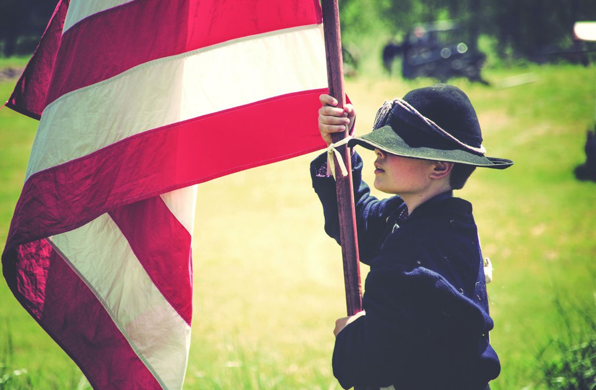 Jason Morrison holds the U.S. flag during a Civil War re- enactment on the Nash Farm battlefield near Hampton, Ga. A Civil War Trust photo contest winner, this image is on the cover of the Trust’s Battlefields Mean Business report. (Bob Reece)