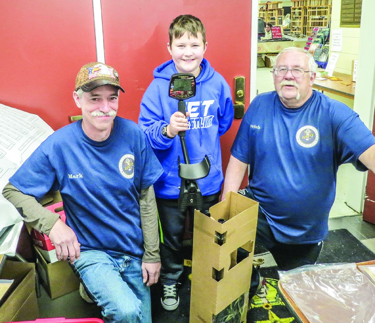 Reece Potts is all smiles after winning one of three metal detectors offered as door prizes by Garrett and First Texas. Flanking him are show committee members (L) Mark Schuessler and (R) Butch Holcombe.