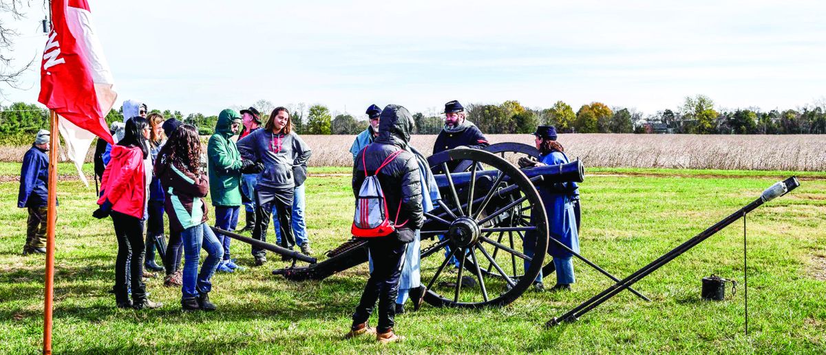 The youth group watching as the cannon crew talks about the gun.