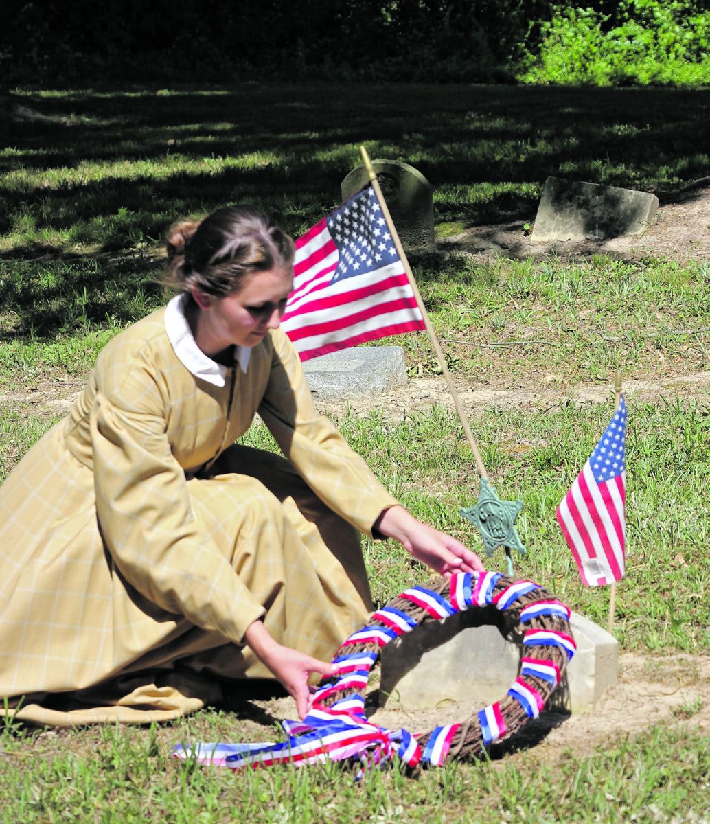 Hancock House. Alyssa Chomo, seasonal interpreter, lays a wreath at the grave of Cornelia Hancock. (Jane Turner)