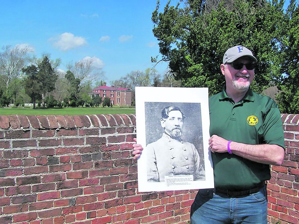 Don Hakenson holds a picture of the Gen. Wickham with the mansion house framed in the background. (Gwen Wyttenbach)