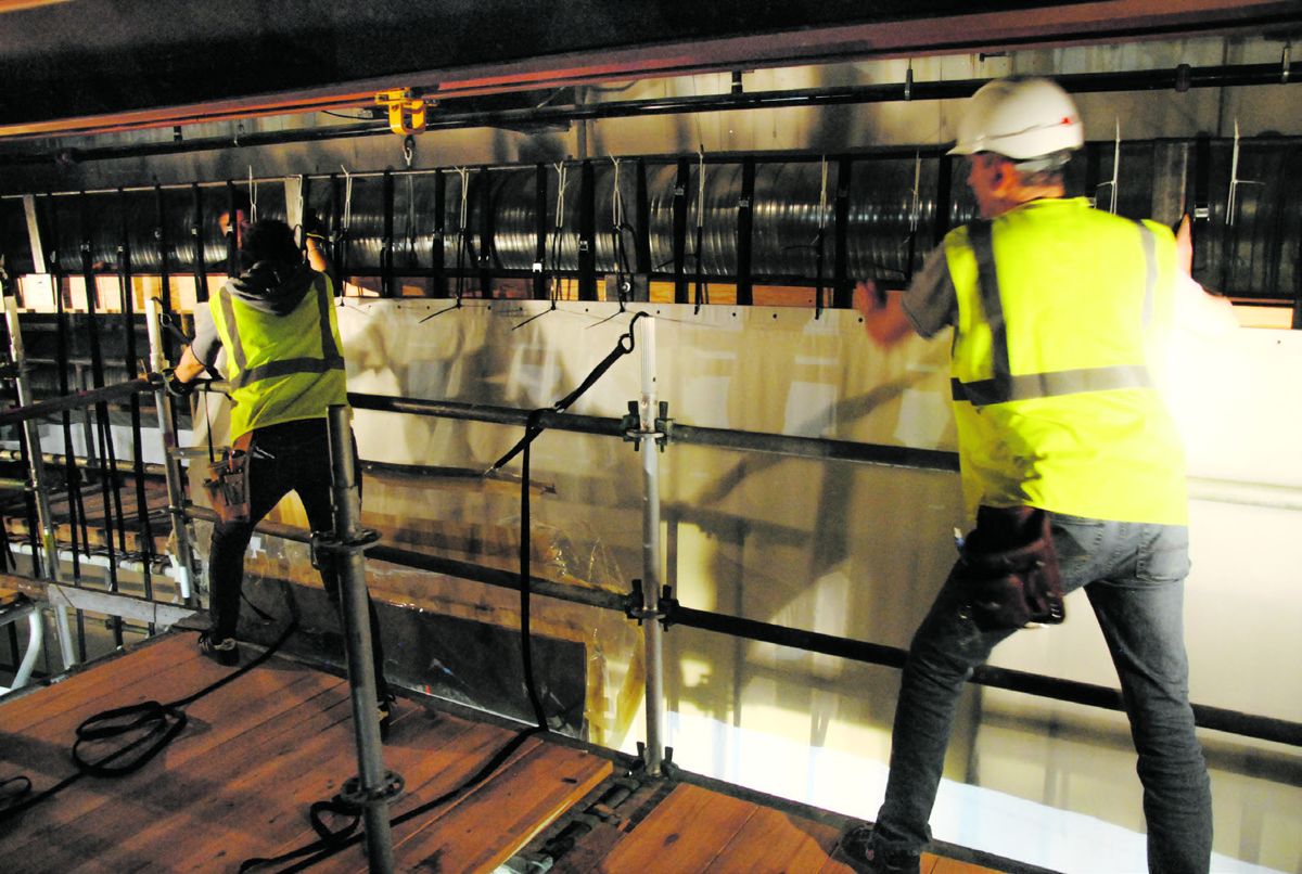 Atop a 50-foot scaffold, conservators attach the top edge of The Battle of Atlanta cyclorama to the adjustable trolley system that allowed the painting to be rotated during restoration. They also added seven feet of new canvas to re- establish the original height of the painting.