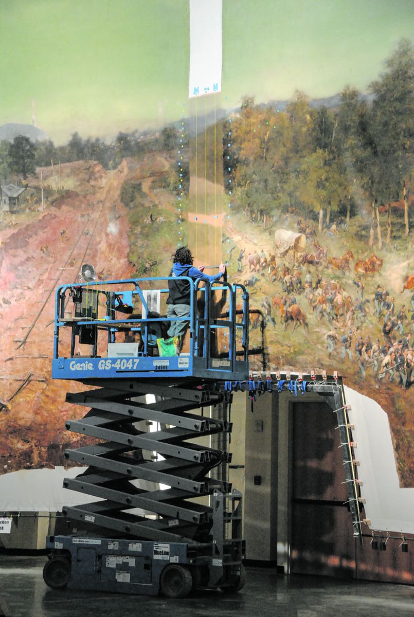 Art conservator Lisa Jarrow fills in the missing 22-inch-wide vertical section over the Decatur Road. This area was excised in 1921 when it was discovered that the painting was too large for the new Grant Park building.