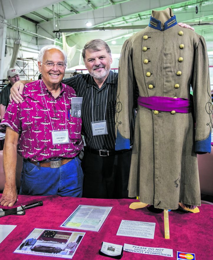 Virginians Lewis Leigh Jr. and Shannon Pritchard stand next to a Confederate 1st lieutenants frock coat that Shannon offered for sale by OldSouthAntiques.com.