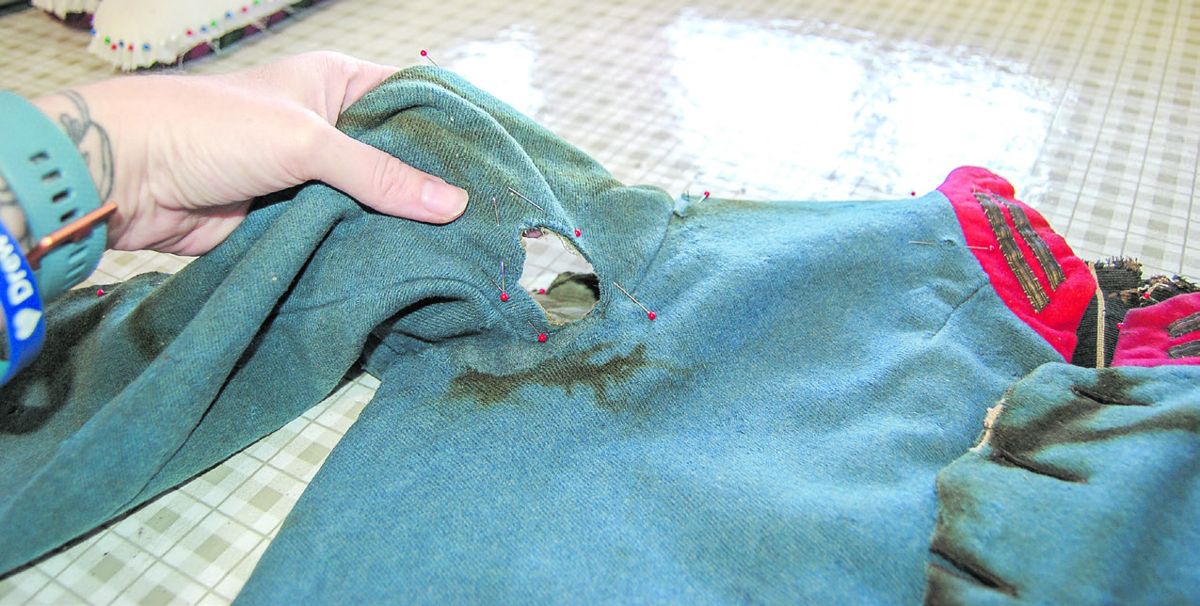 Bullet hole in right arm of coat.