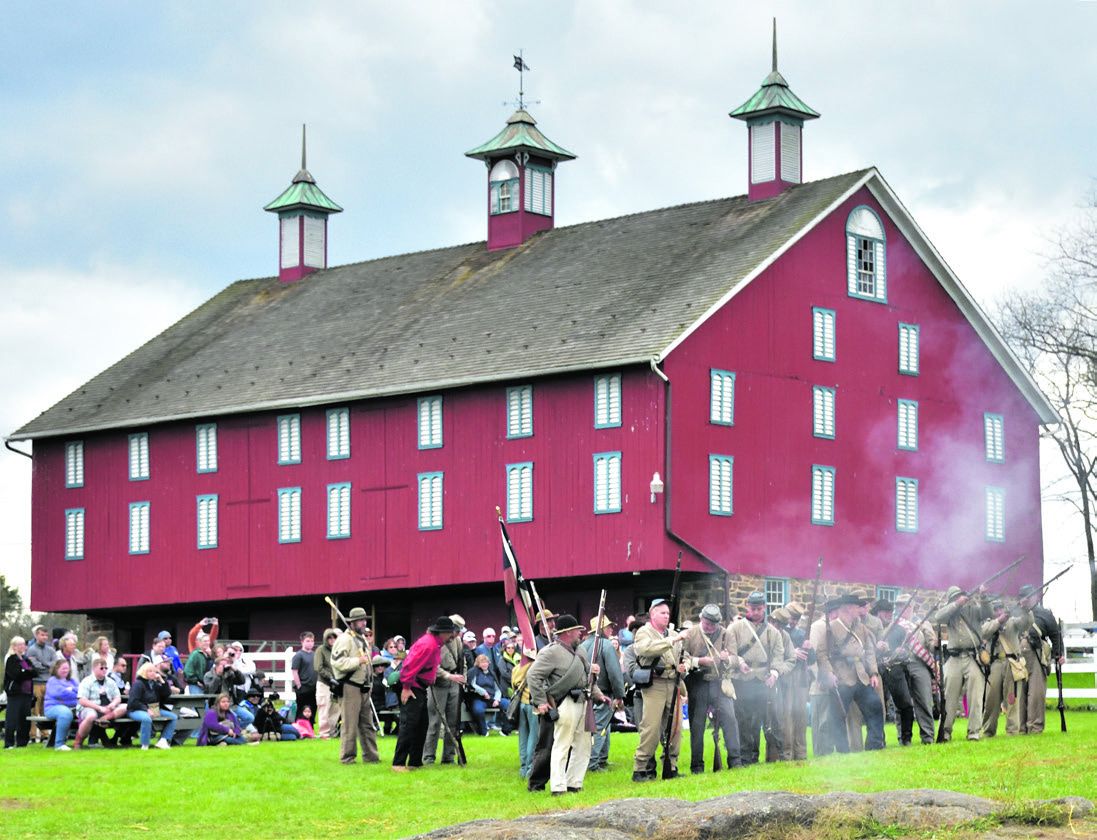 A line of reenactors in front of the historic Daniel Lady Farm’s historic barn.