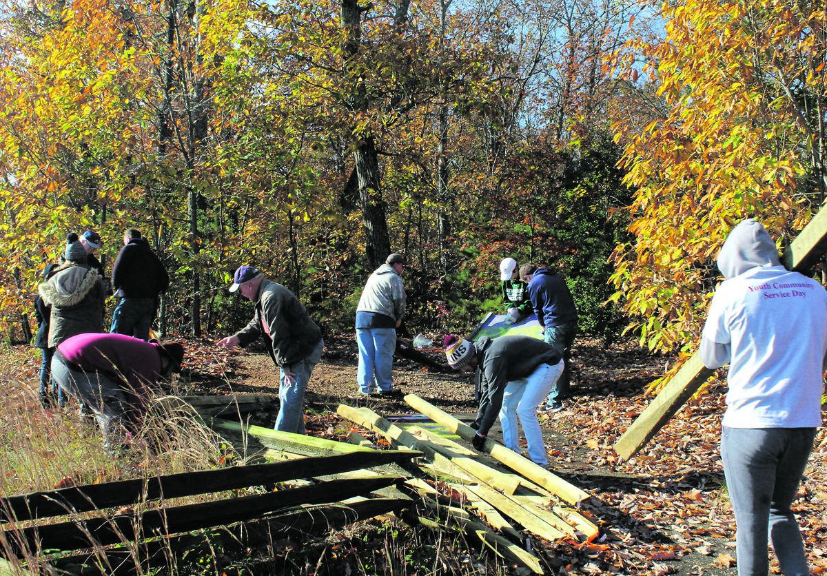 Riverbend High School students rebuild split rail fence on Anderson Ridge.