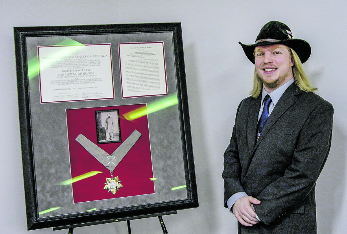 Justin Smith of Cumming, Ga., stands next to the Confederate Medal of Honor bestowed by the Sons of Confederate Veterans to his ancestor, Col. Hume R. Feild.