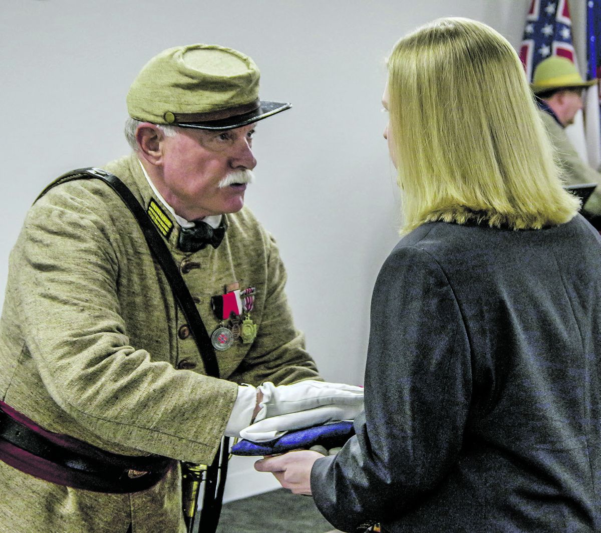 Ralph Mills, Commander of the SCV Camp 1404, presents to Justin the flag that was draped over the Medal. (Photos by Jim Dean, Forsyth County News)