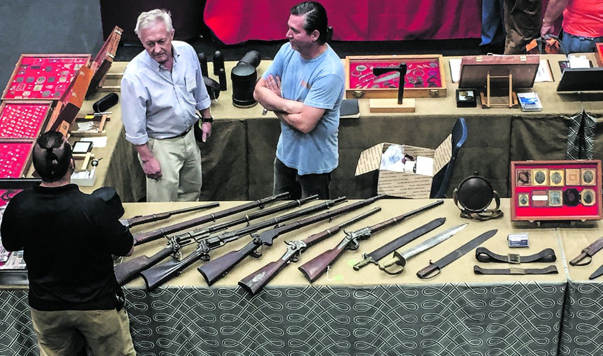 Wallace Markert and Nick Periut at their sale tables having a conversation with Brian Akins.