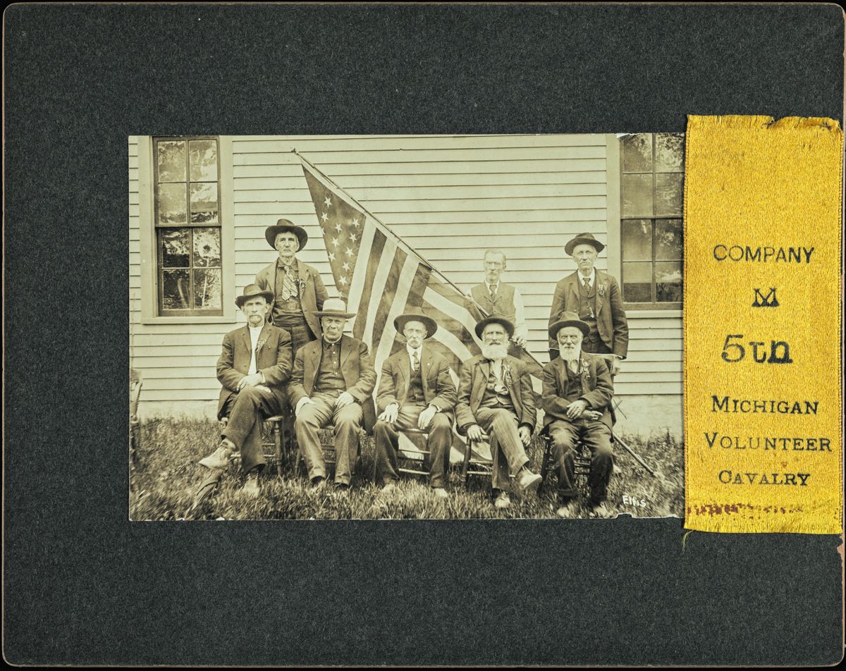 Reunion of unidentified Co. M, 5th Michigan Cavalry Regiment veterans, in GAR uniforms with American flag. (Liljenquist Family Collection of Civil War Photographs, Library of Congress)