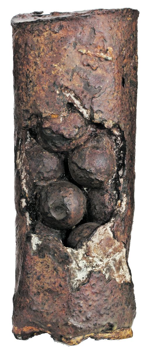 Hotchkiss canister with its iron canister balls exposed. These canister shot are similar to what is embedded in the wood beam.