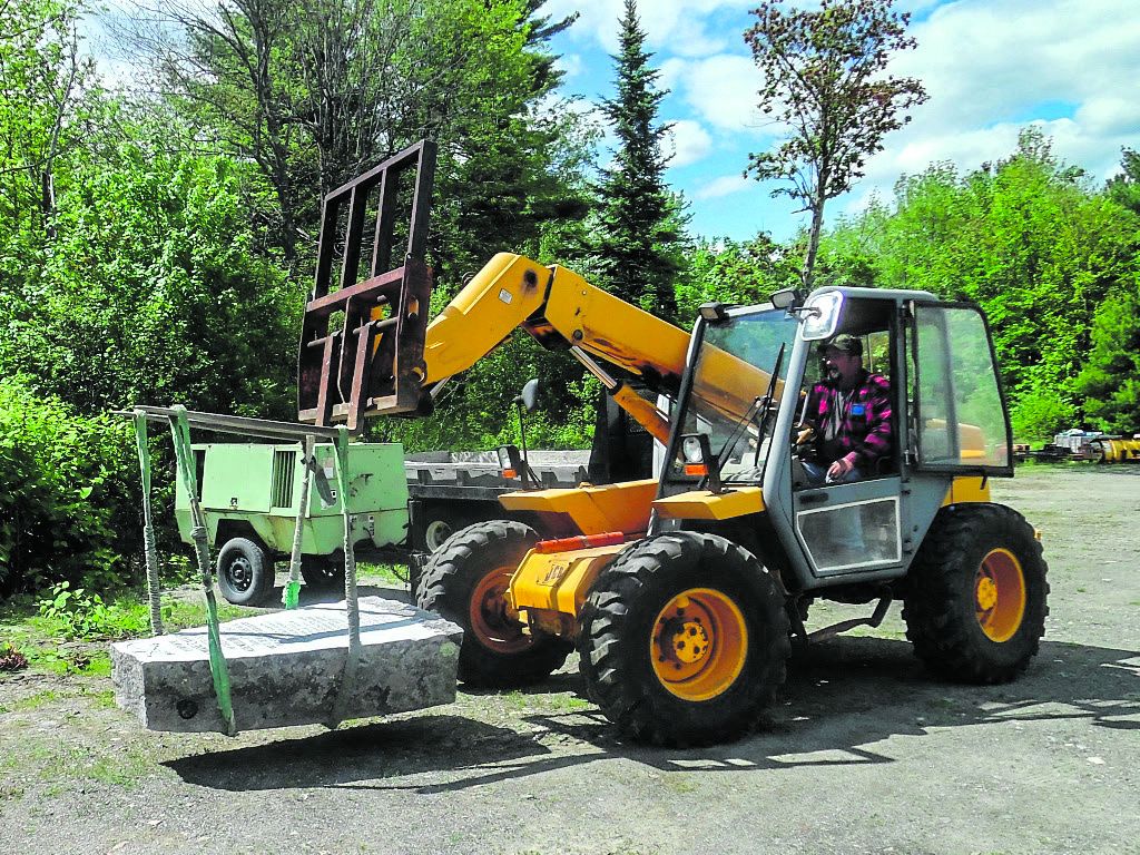 Dave France, of Troy, Maine, drives the forklift that transferred the completed monument stone to a rental truck.
