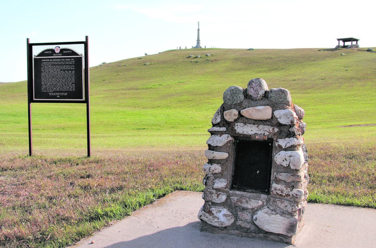 A view from the Sioux village site to monument hill. In the foreground is the Sioux memorial and to its left the North Dakota Historical Society’s marker. Above and to the right of the Sioux memorial is one of the CCC built shelters; to its left is the monument to the 2nd Nebraska and 6th Iowa.