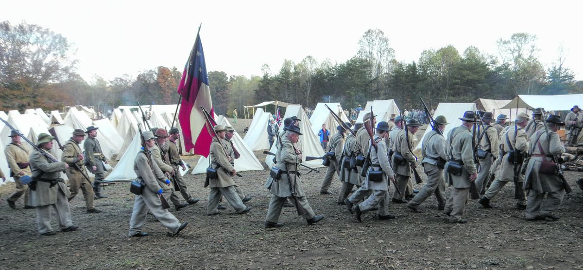 Confederate reenactors marching through camp.