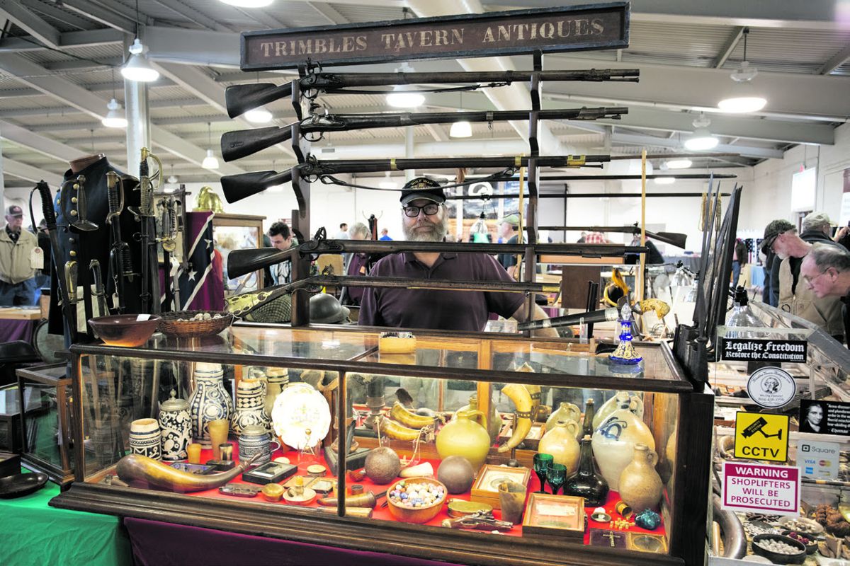 Chris Trimble peering from behind his gallery of early Americana.