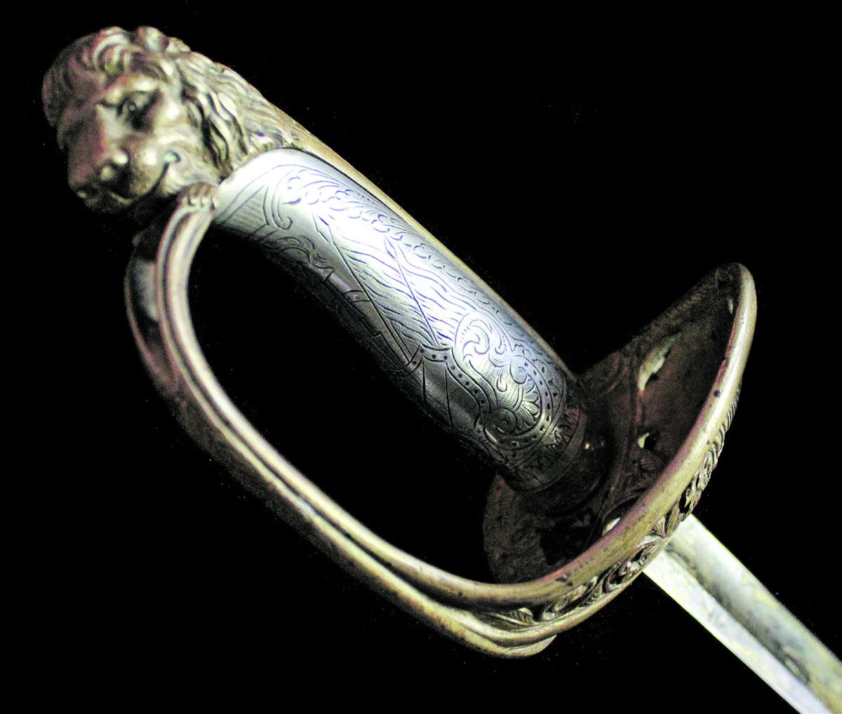 The sword features an exquisitely engraved, coin silver grip.
