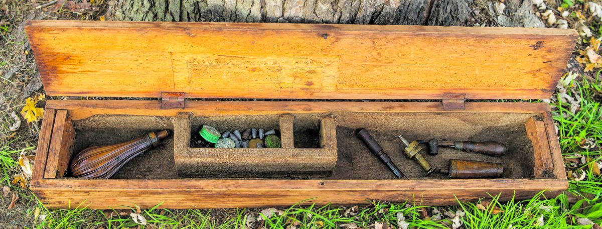 The old wood case retains two old brass powder flasks, the original brass/iron bullet starter for a false muzzle and “picket bullet” mold.
