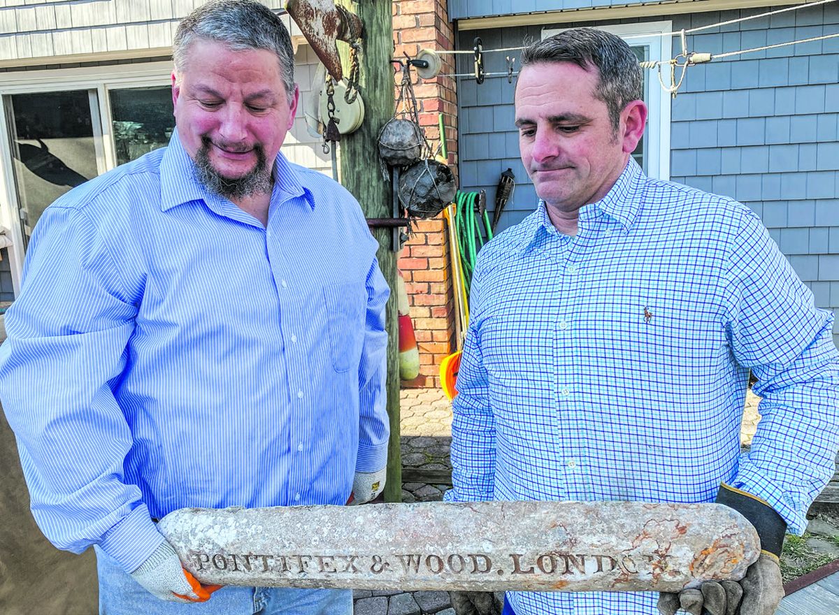 Andrew Favata and Jim DiSciullo with the lead ingot they recovered. (Bill Bleyer)