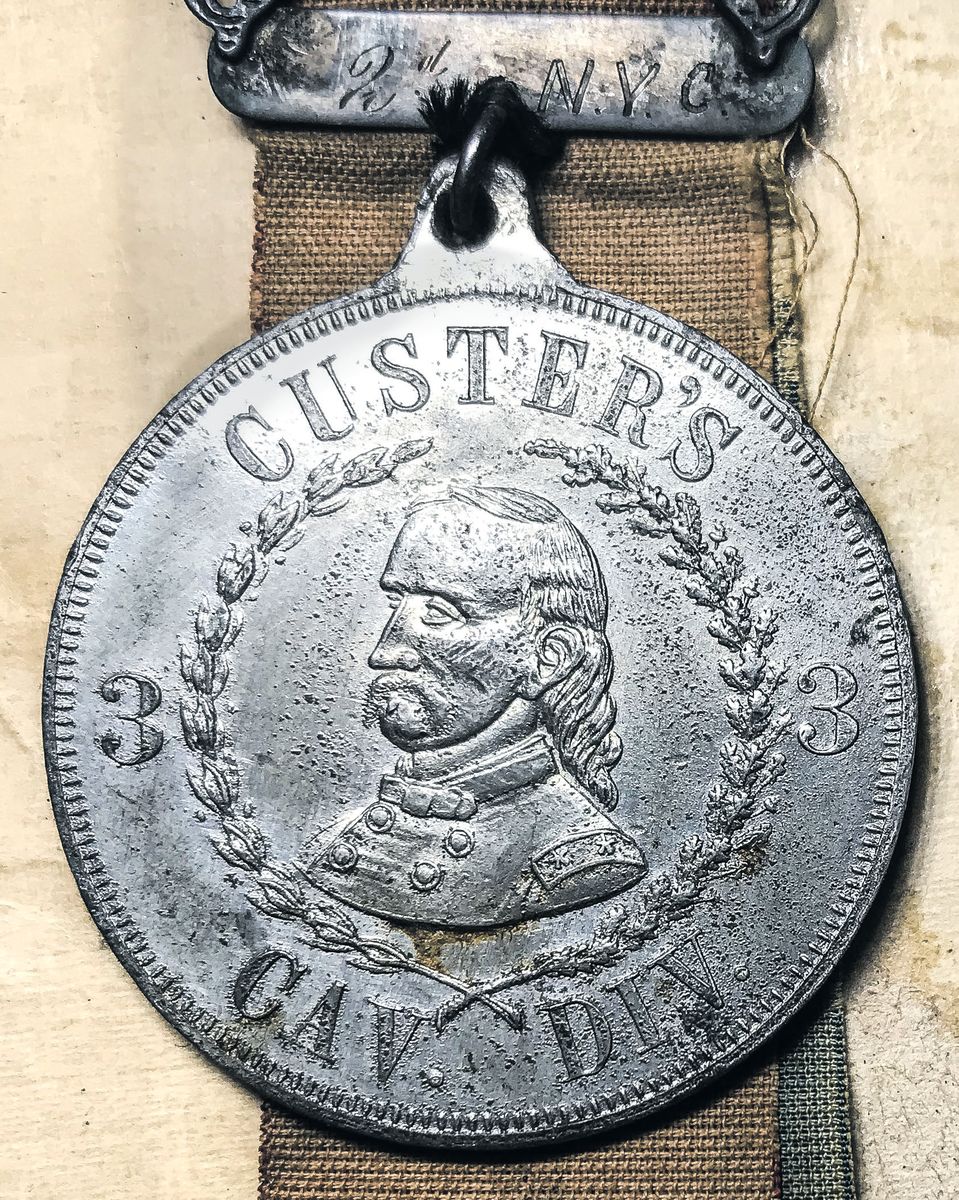 Close-up of obverse of 35 mm medallion of ID pin with Custer bust and 3rd Division markings. Top bars inscribed: “ D. J. Underhill / 2d N.Y. C.”